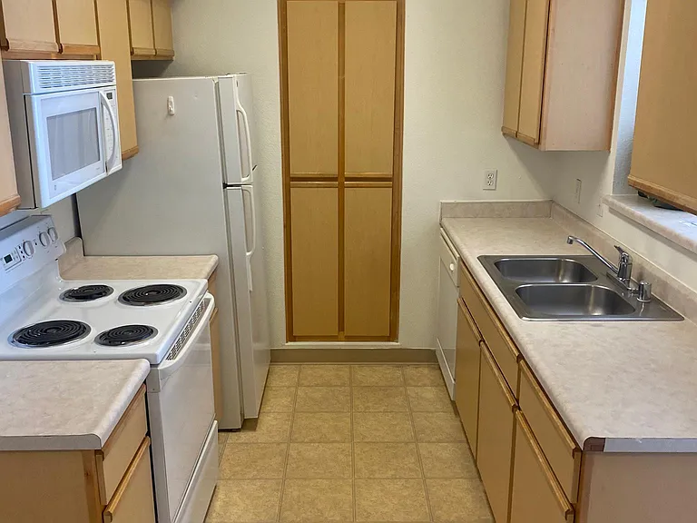 Kitchen with appliances with washer and dryer too in separate laundry room.