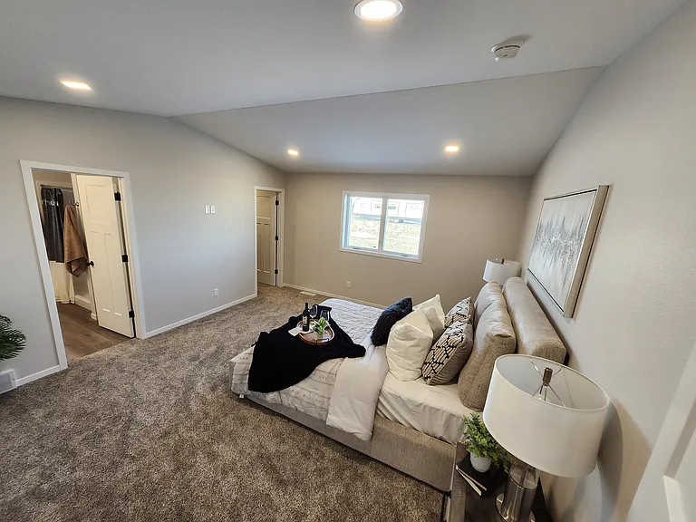 Extra large primary bedroom looking to closet and bathroom. (Pictures are of another unit with similar finishes and features.)