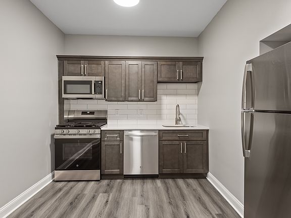 Kitchen with dishwasher, new cabinets, new appliances and quartz countertops.