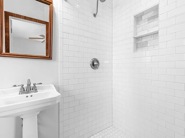 The updated primary ensuite features a beautifully tiled walk-in shower with a built-in niche.