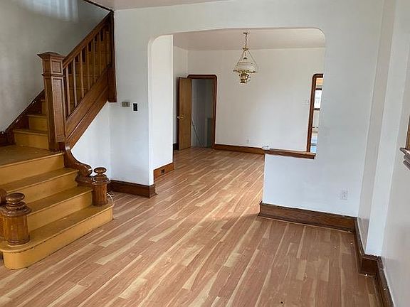 Front part is living room and stairs leading to second floor. Back portion is family room. LHS door leads to basement while RHS opening is for the kitchen.