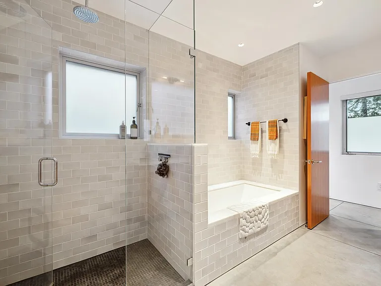 Main bathroom with shower and tub, heated floors and towel rack.