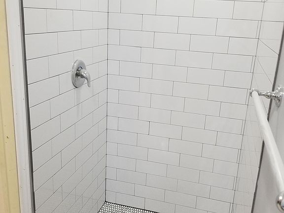 Stylish shower with subway brick pattern and penny tiles