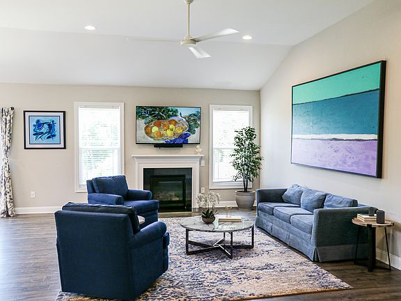The living room is very open and great for entertaining. You will notice in the next photo it has a loft like feeling with 11 foot ceilings and open concept living. That is a gas fireplace and the windows on either side face nature and excellent sunsets.