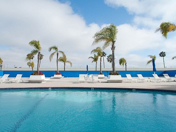 Outdoor swimming pool with sundeck and lounge seating.
