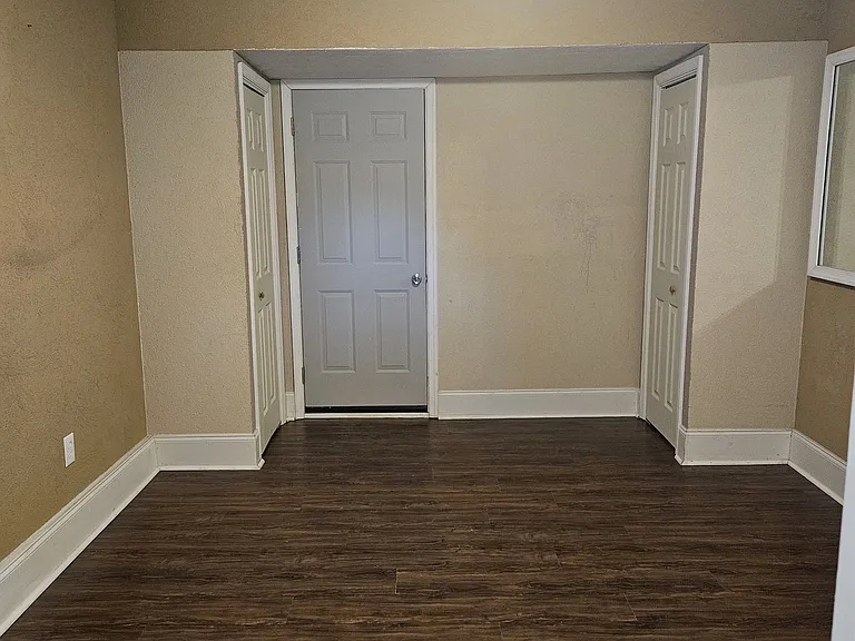 Bedroom #3 w/access from kitchen, garage space and exterior door to the back/side yard. Two closets are on either side of the back of the room.