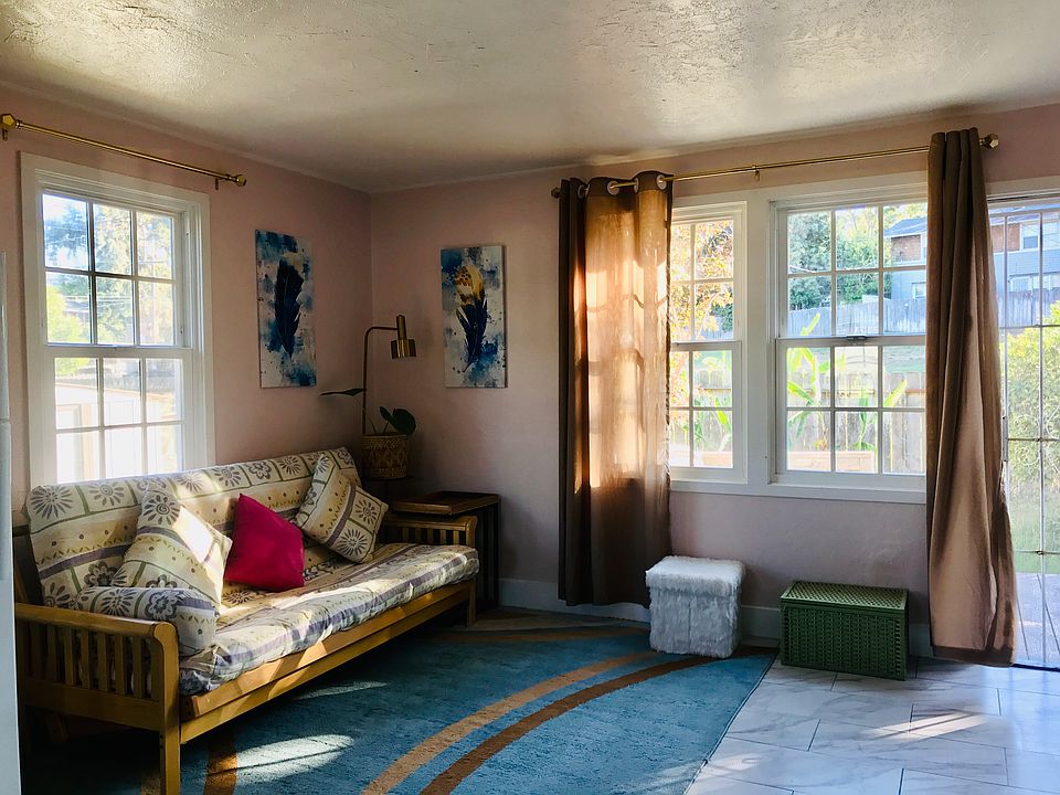 This corner is the most beautiful spot of our living room. Pink wall match brown curtain and blue rug perfectly.