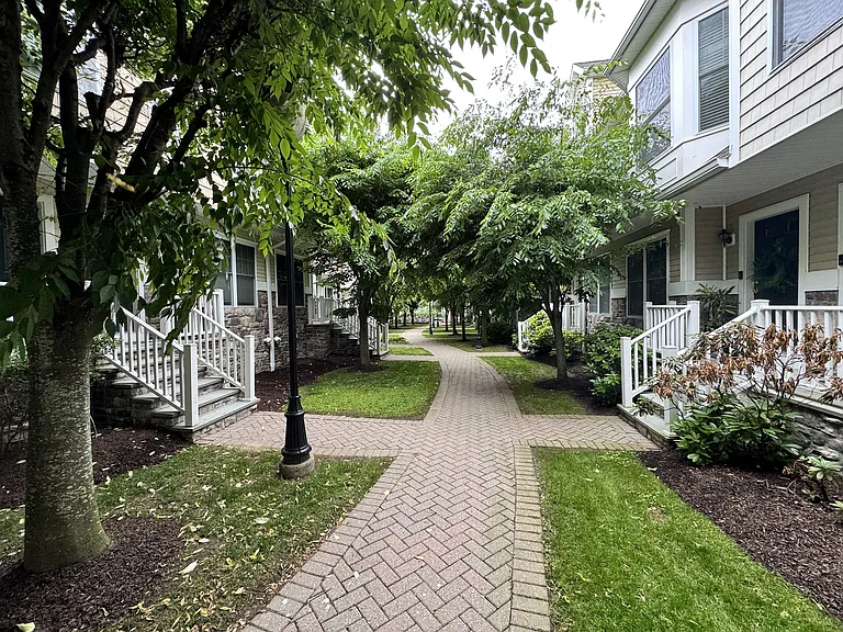 Front door opens to a treelined courtyard