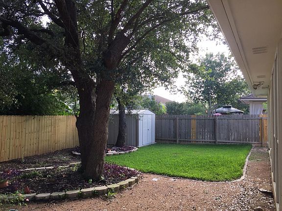 Shady back yard with storage shed