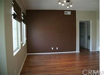 Living room on 1st floor with wood flooring & custom window