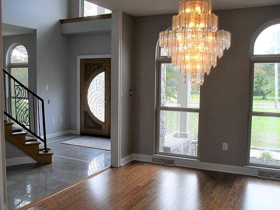 Dining room with chandelier and front entryway. Stairs go to second floor.