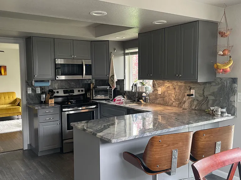 Newly remodeled Kitchen with all appliances and bar stools at the granite countertop.