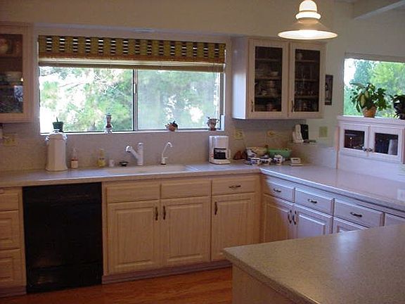 Spacious kitchen with solid surface countertops and wood floor