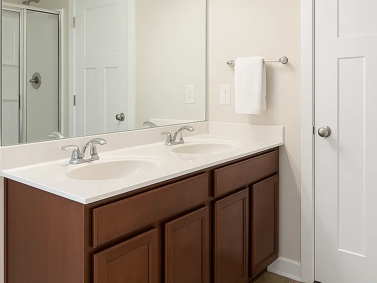 Dual-sink vanity with modern finishes and a glass-enclosed shower for a spa-like feel.