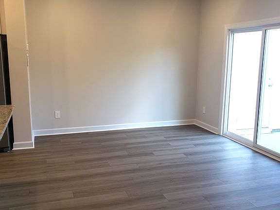 Open spaced living area includes vertical blind and 2 " window blinds