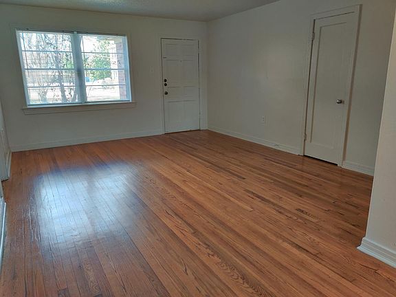 Living room with a large closet (door seen on right). Apartment entry door is near the windows.