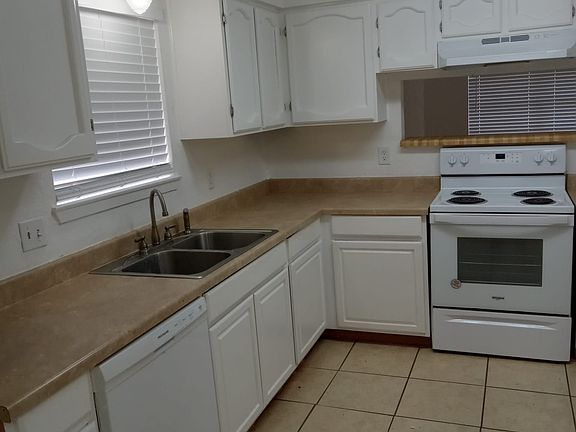 Bright kitchen with new stove, sink has sprayer, and breakfast nook
