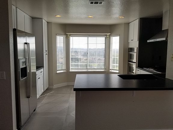 Bright, well-appointed kitchen with stainless steel appliances and tile flooring.