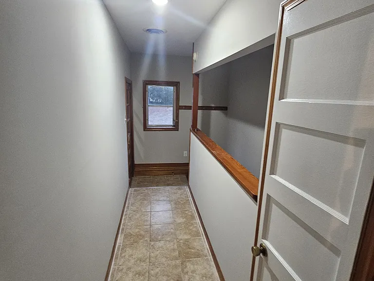 Tile floors in hallway leading to the back door and basement.