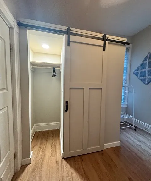 Closet with a barn door. Storage above to keep your suitcases.