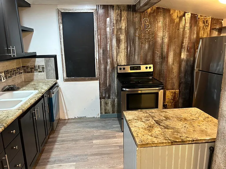 Kitchen with stainless dishwasher, stove, and fridge.