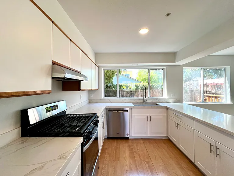 Kitchen with marble countertops looks out to backyard