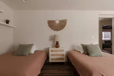 Spacious bedroom with two full beds, soft neutral bedding, and plenty of natural light. Clean and airy, it's a comfortable, functional space for a restful stay.