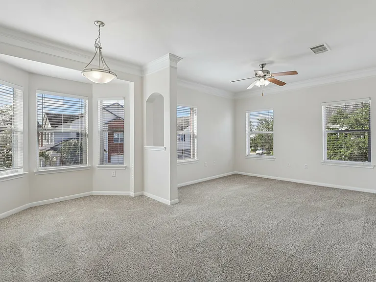 Bright and spacious living room with large bay windows and soft carpet flooring, perfect for relaxation and natural light. Bright and spacious living room with large bay windows and soft carpet flooring, perfect for relaxation and natural light.
