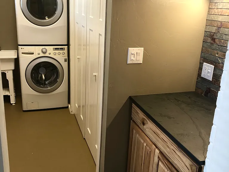 Coffee bar with under counter lighting, Front loader washer/dryer, Large storage closet in Laundry room with shelves and extra hanging rods.