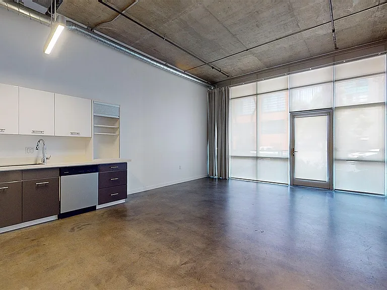Apartment dining and living room with polished-concrete flooring.