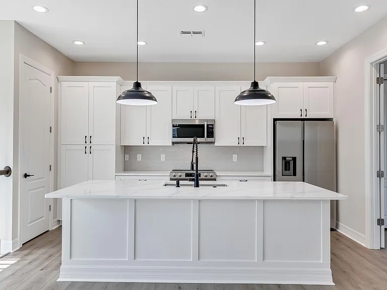 View of the kitchen that includes the island, cabinets, and appliances. Facing north.