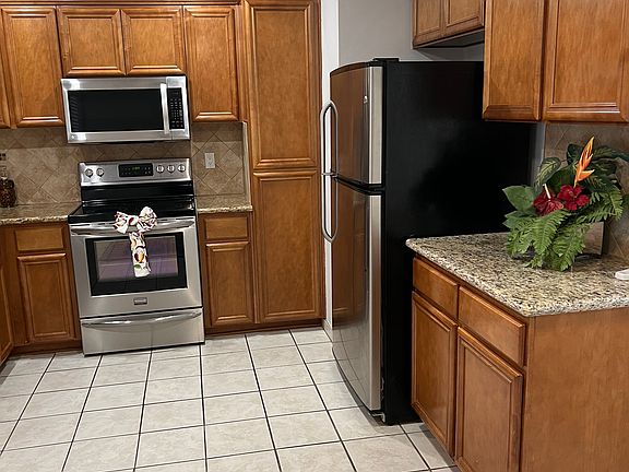 Kitchen with all stainless steel appliances- dishwasher, electric stove, microwave & refrigerator