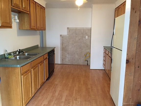 Kitchen is galley style with brand new stove and exhaust fan