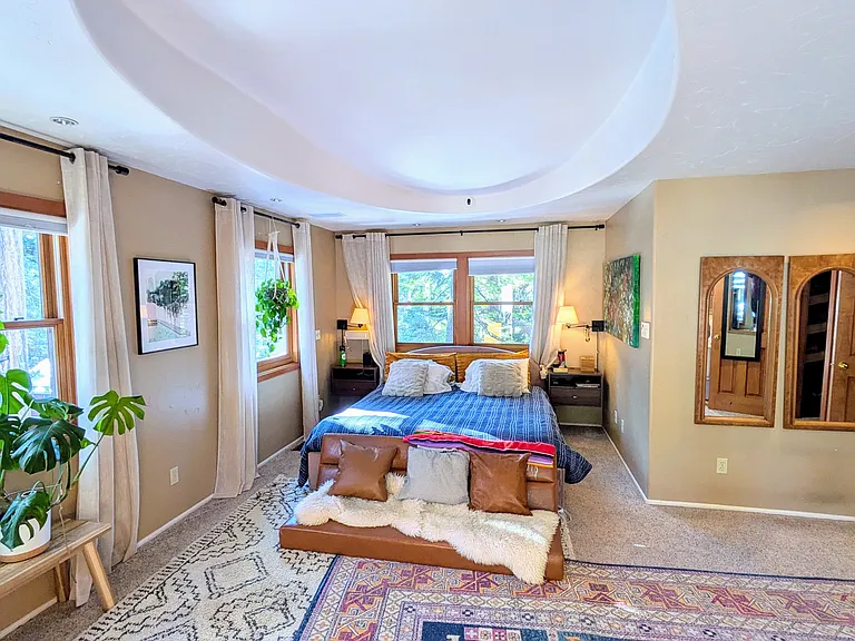 Primary bedroom with ensuite, walk-in closet, king bed, private deck, and gas fireplace