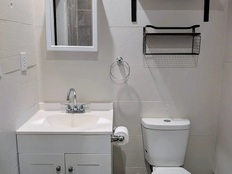 Bathroom sink with vanity plus additional shelving.