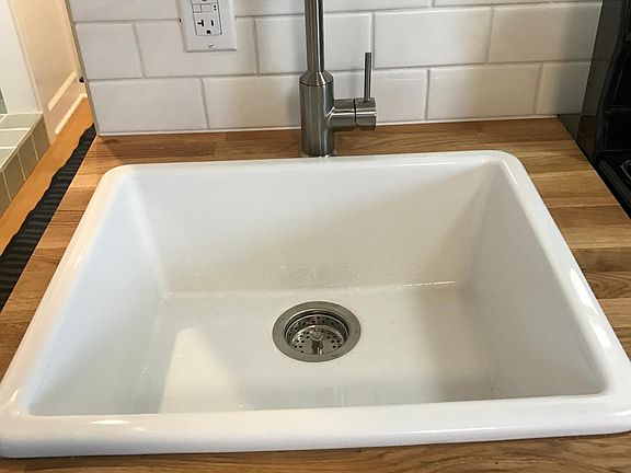 Farm house sink, ample water pressure and tile backsplash allow for full-on cooking.