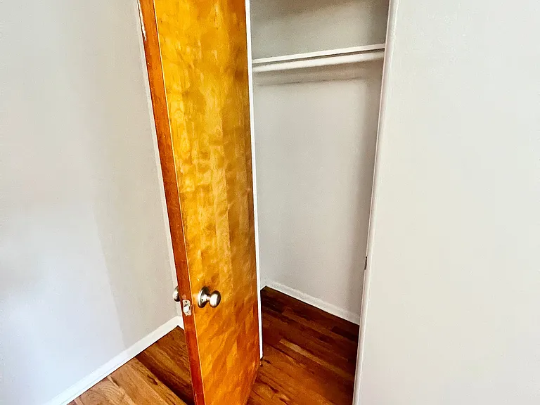 Spacious closet with polished wooden flooring, perfect for stylish storage solutions. Spacious closet with polished wooden flooring, perfect for stylish storage solutions.