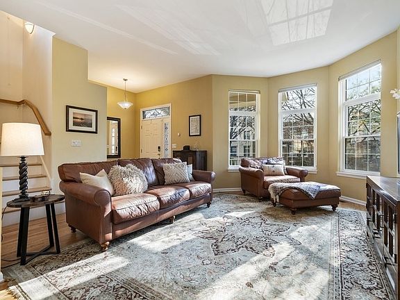 Sunlight pours through the tall windows of the main living area. A foyer area provides a closet, an