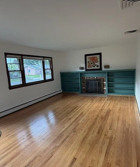 Living room with hardwood floors and fireplace. Beautiful bookcase and molding.