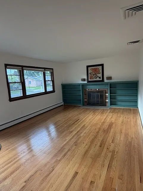 Living room with hardwood floors and fireplace. Beautiful bookcase and molding. - 304 Ayr St NW