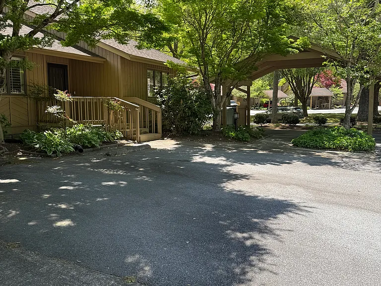 Front deck, parking space and carport.