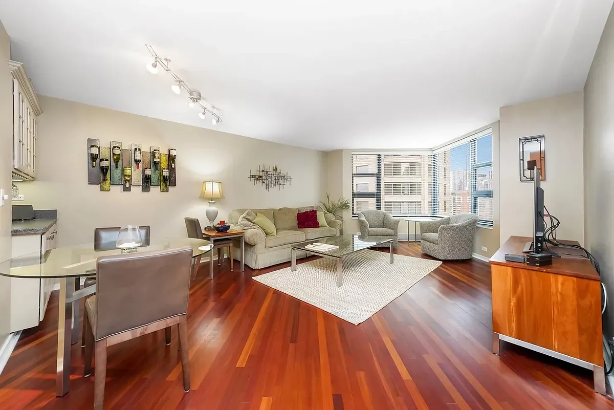 Photo 2 of 20 - 401 E Ontario St #3004 - Chicago, IL Living room with wood flooring, now includes built in entertainment center on right wall with extra storage and room for TV - 401 E Ontario St #3004