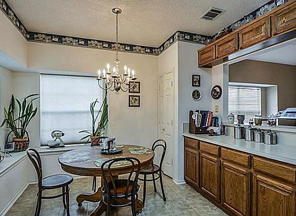 Eat-in kitchen with bar open to dining / play room. [Wallpaper border is gone.]