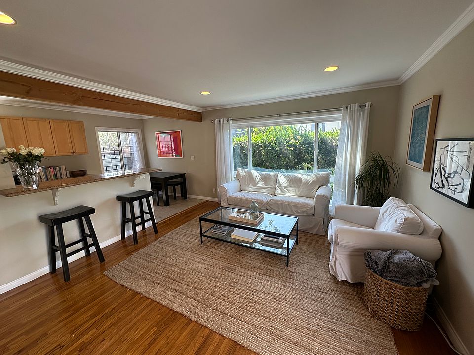 Living room and part of kitchen shown furnished.