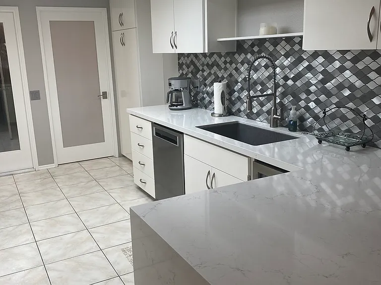 Other side of Chefs kitchen with deep farm sink and wine refrigerator. Frosted door leads to full size laundry room with washer and dryer.