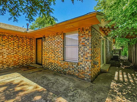 Front door and sitting area with sliding doors and entrance to backyard shown.
