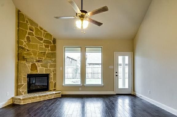 Family room includes wood flooring and beautiful stone fireplace