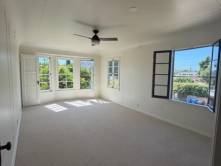 Large master bedroom with 2 closets and view of mature orange tree.