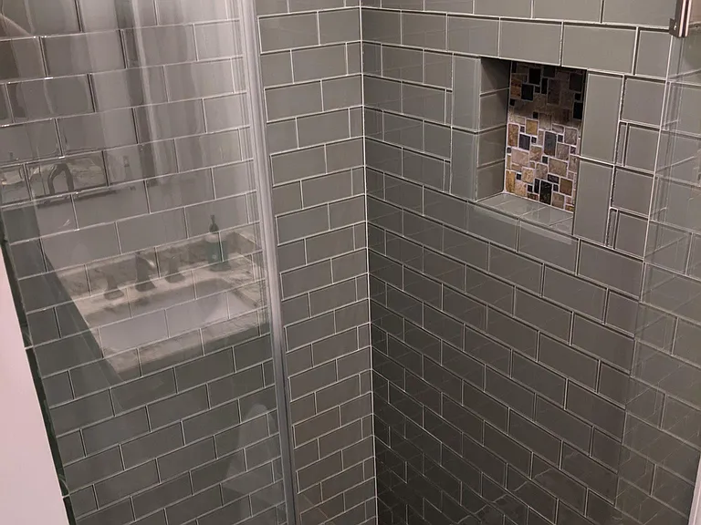 designer shower with overhead shower head, glass tile, and slate floor