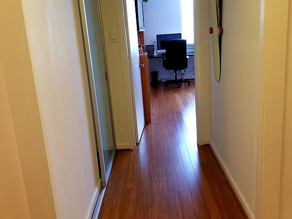 hallway with a mirror and a coat hanger, a closet behind a